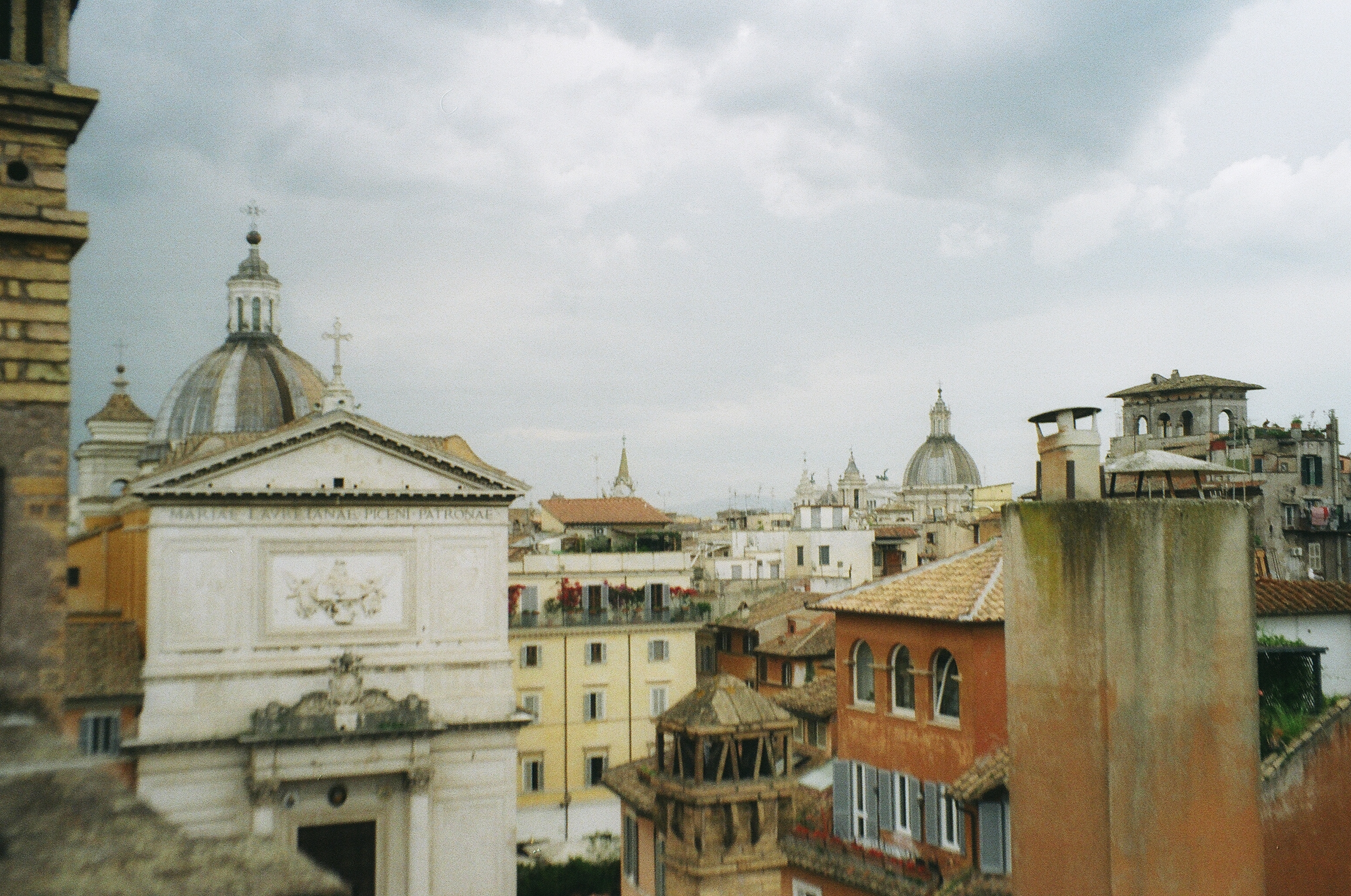 This image depicts the many different architecture styles of the Rome Rooftops in Italy with many Domes and angled tiles.