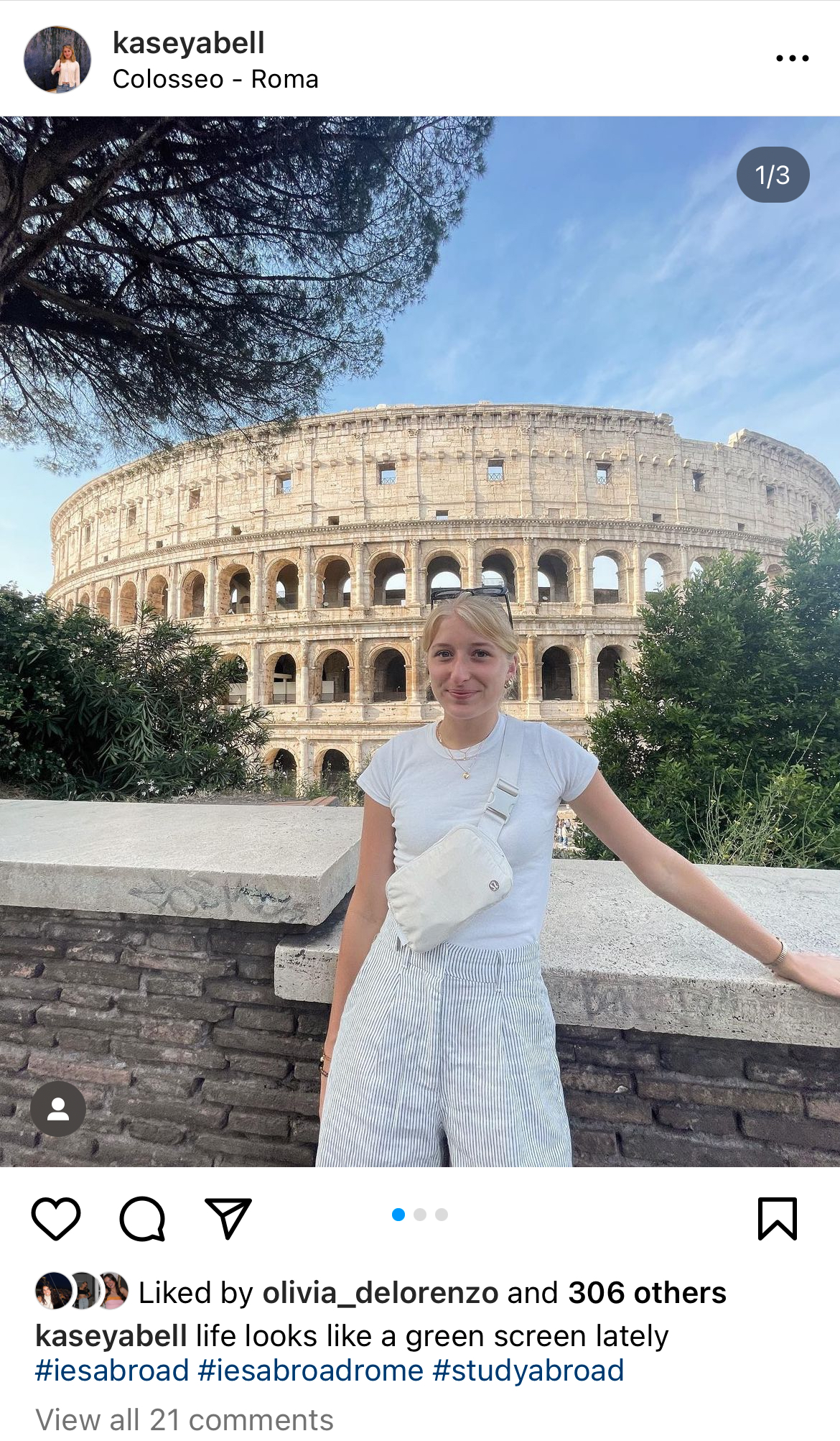 This instagram post depicts a young white blonde girl standing in front of the colloseum in Rome. She is wearing a white tee shirt and pin striped cream shorts. She has sunglasses on her head and her hair in a ponytail