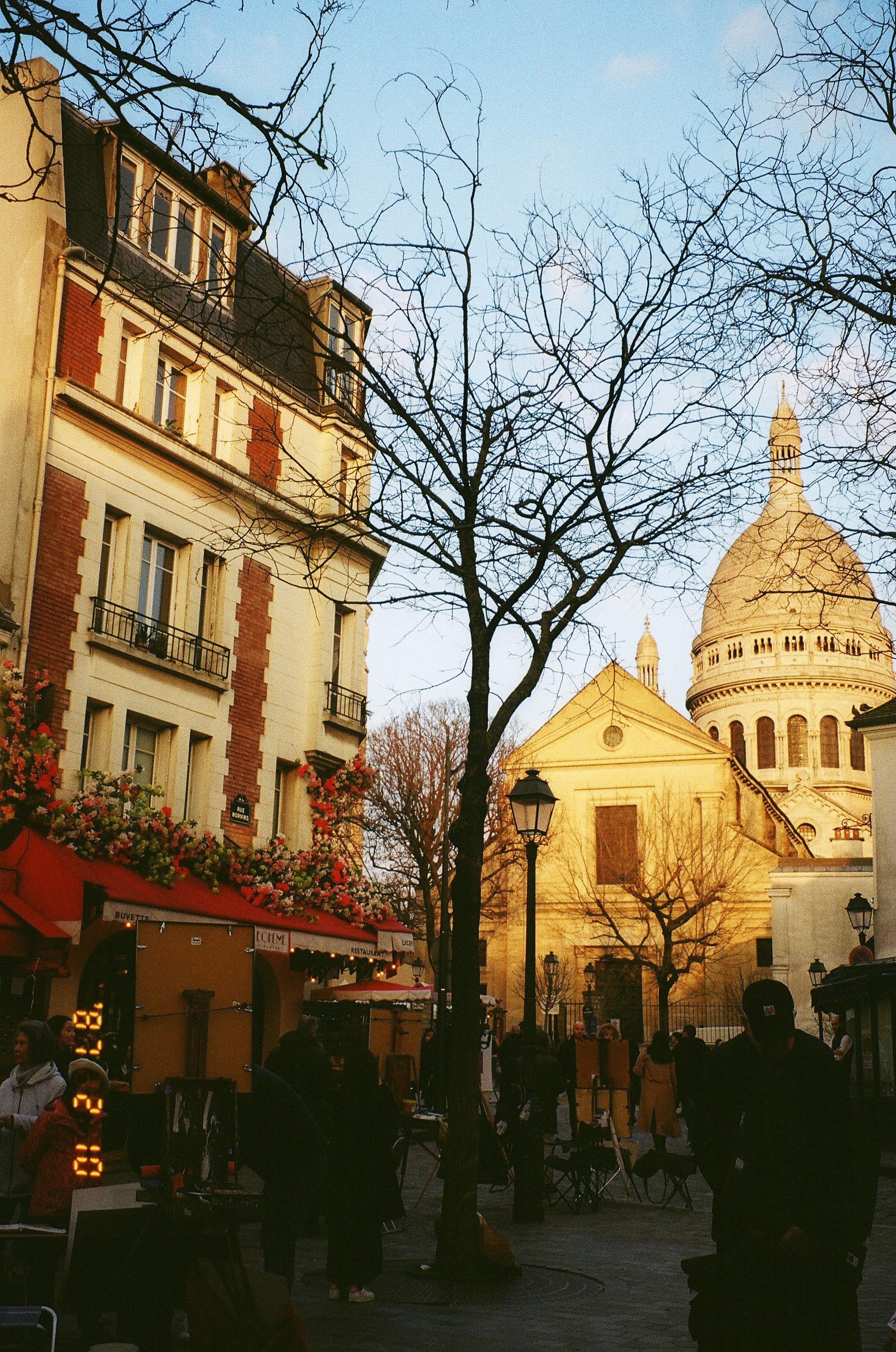 This image is from Montmarte Paris, looking up at the beautiful cathedral SacreCoeur. The sun is setting, so the golden yellow light is hitting so nicely on the beautiful white facade of the cathedral and the stone domes.
